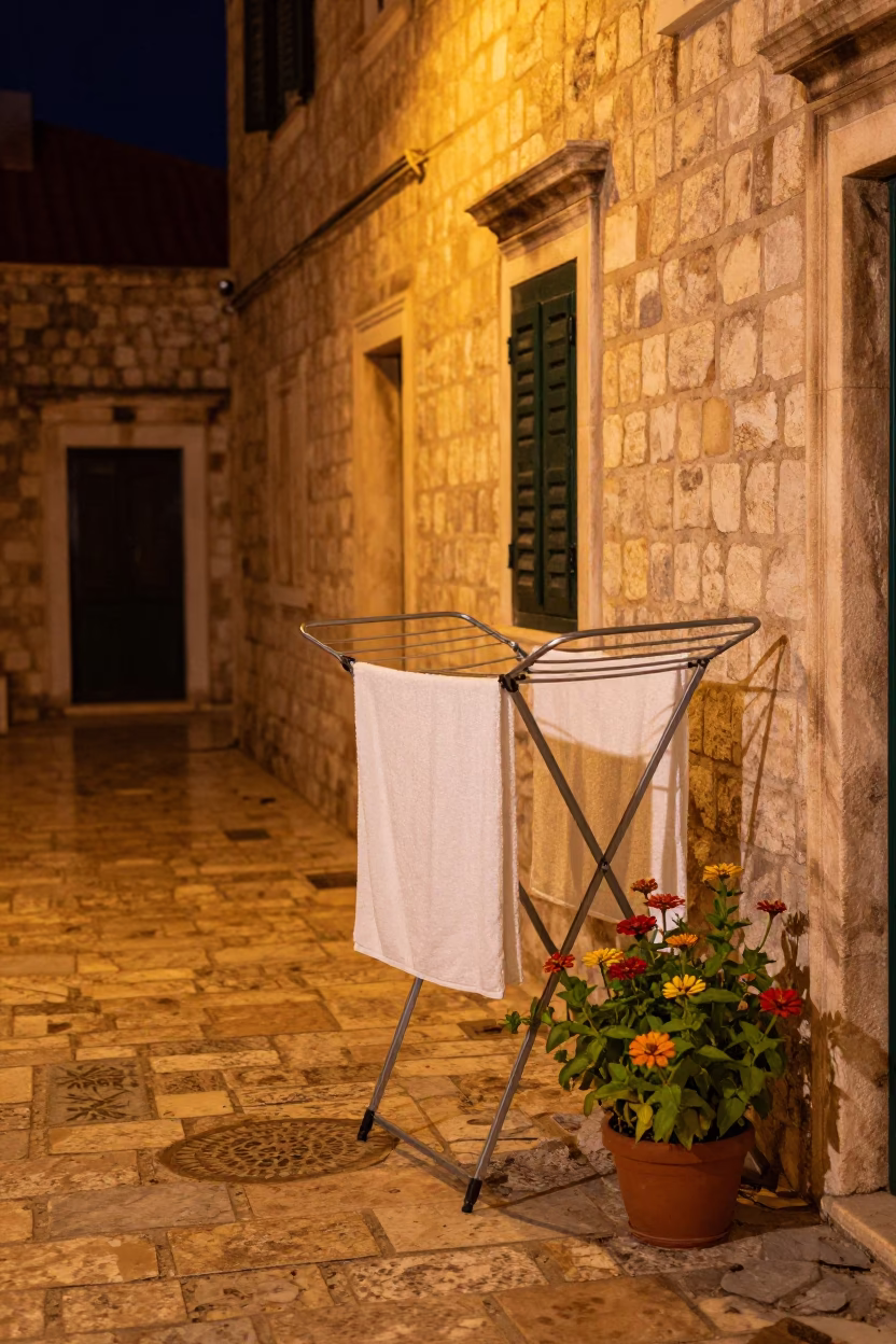 Nighttime Dubrovnik alleyway with drying rack and zinnias under sodium lamp in in Dubrovnik, Croatia