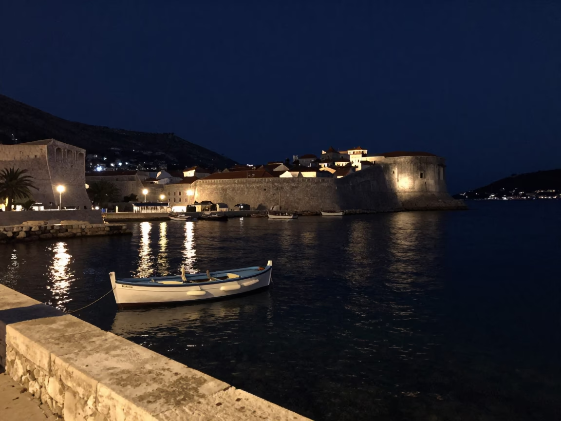 Nighttime Dubrovnik Harbor Scene with Rowing Boat and Stone Walls in in Dubrovnik, Croatia