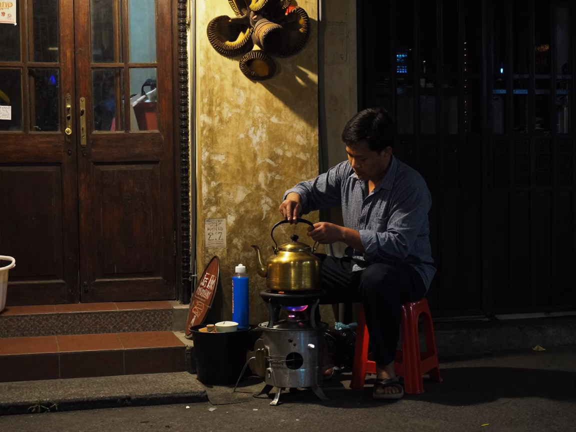 Nighttime Hanoi Street Scene with Vintage Tea Kettle and Local Interaction in in Hanoi, Vietnam