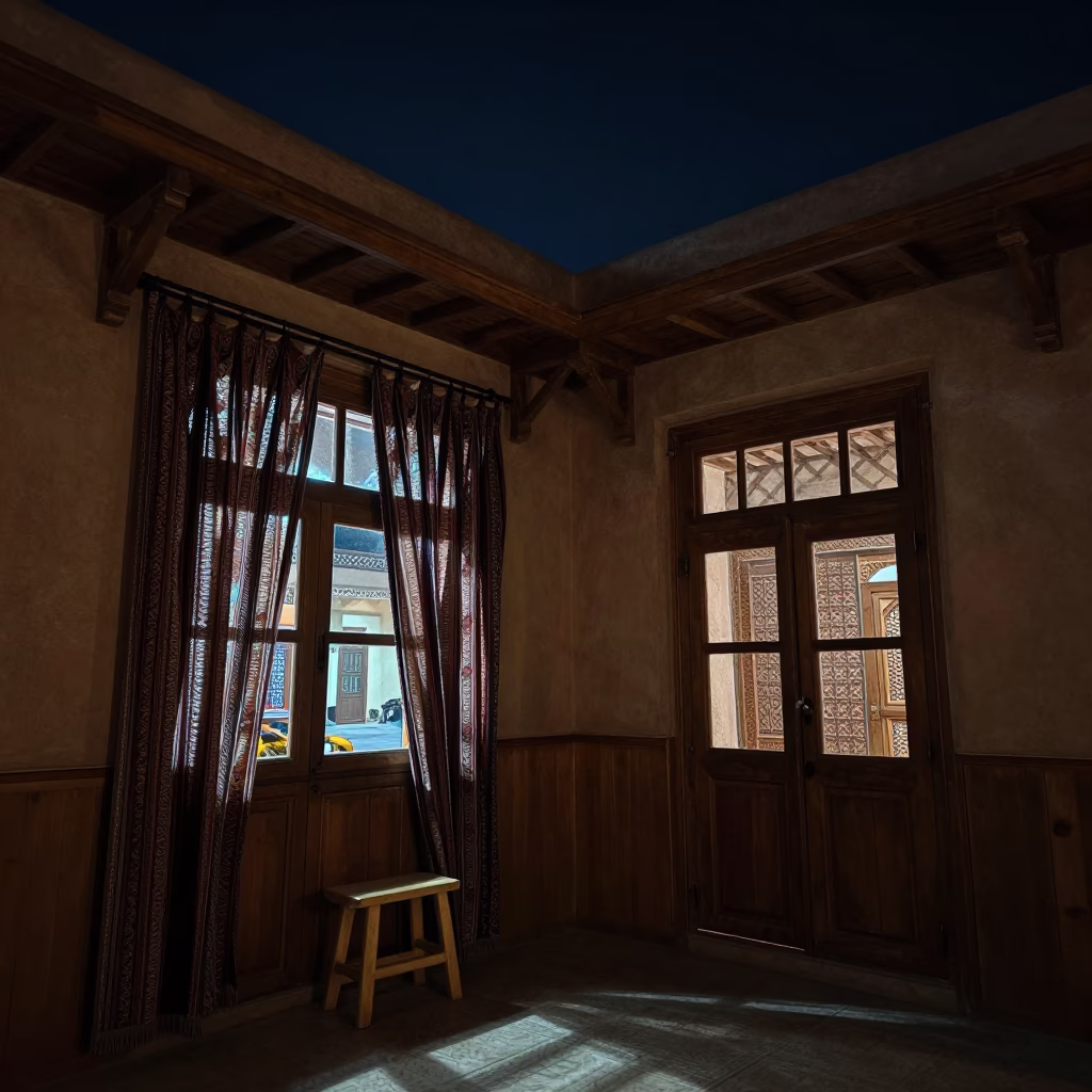 Nighttime Interior of Traditional Fez Riad Room with Wooden Stool and Hanging Curtains in in Fez, Morocco