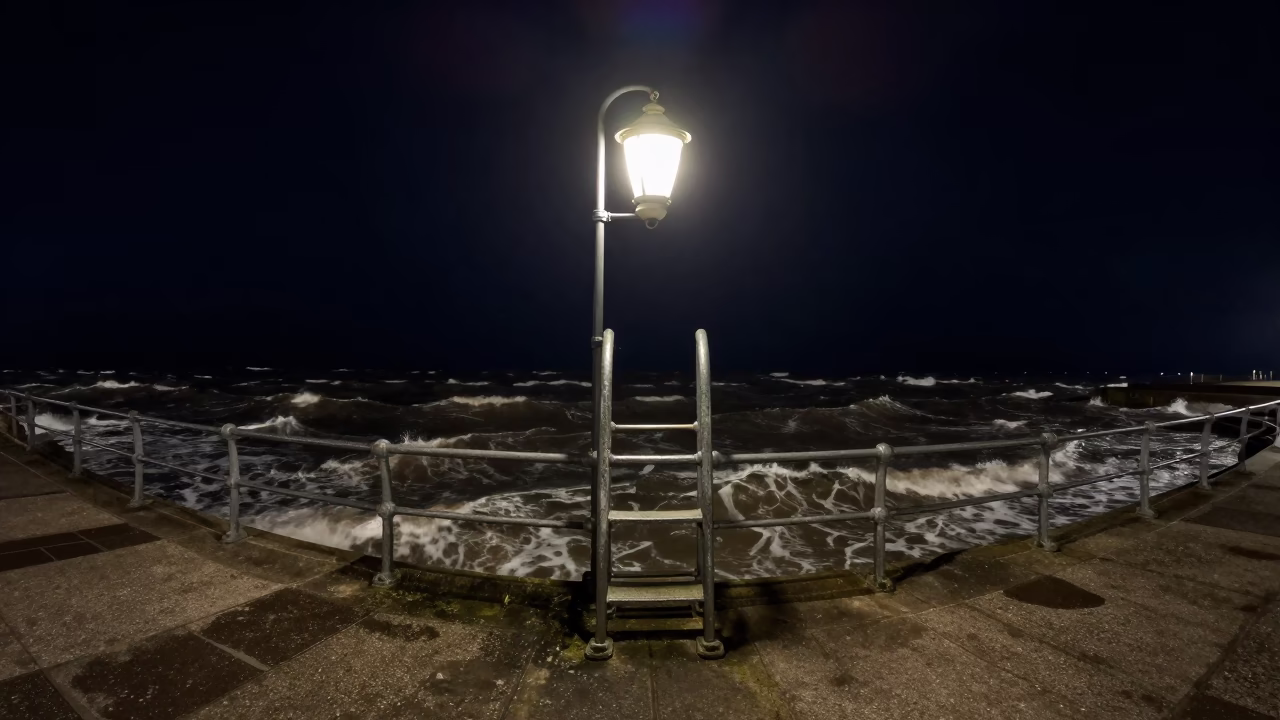 Nighttime Lantern Light on Liverpool Pier Ladder Above Choppy Estuary Water in in Liverpool, United Kingdom