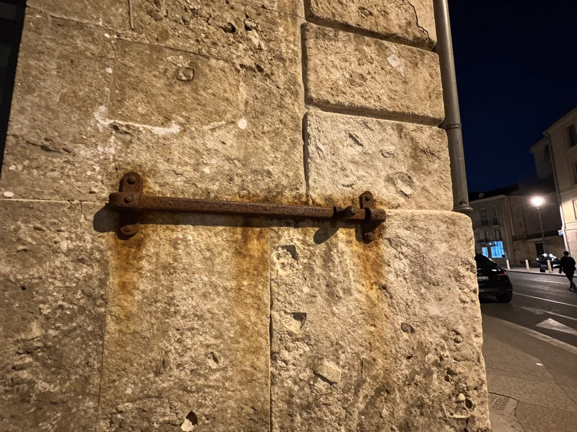 Nighttime Marseille Street Scene with Rusty Metal Latch and Water Bottle on Stone Wall in in Marseille, France