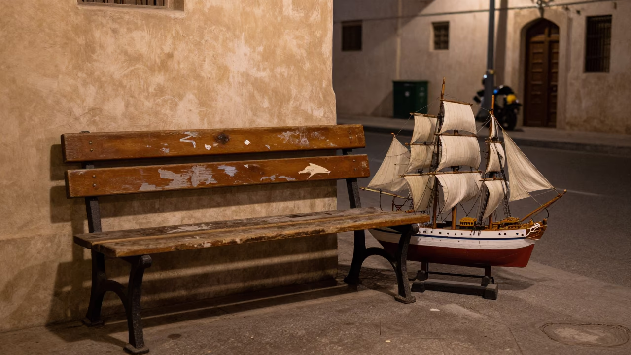 Nighttime Muscat Street Scene with Model Ship and Scratched Wooden Bench in in Muscat, Oman