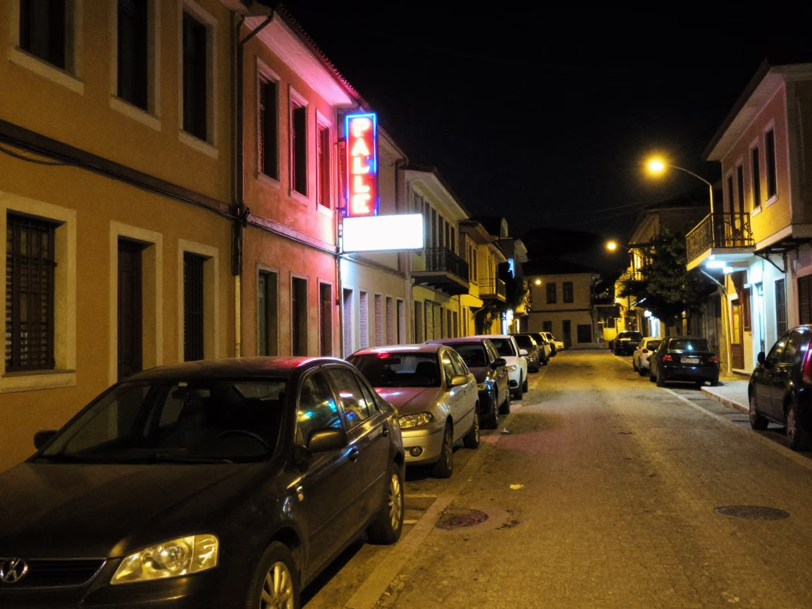 Nighttime street scene in Athens Greece with neon signs and parked cars in in Athens, Greece