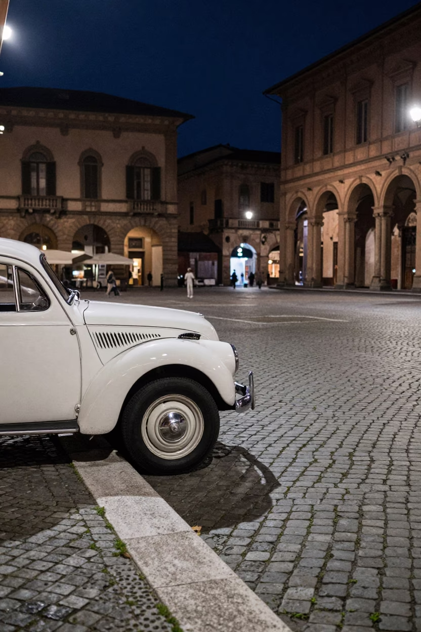 Nighttime Street Scene in Bologna Italy with Vintage Car and Cobblestone Piazza in in Bologna, Italy