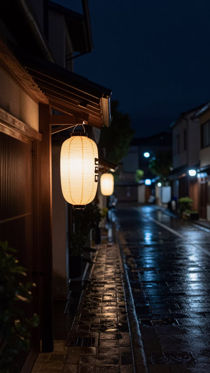 Nighttime street scene in Fukuoka Japan with glowing lantern and wet pavement in in Fukuoka, Japan