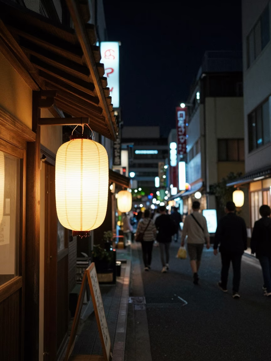 Nighttime Tokyo Street Scene with Glowing Paper Lanterns and Diners Eating from Serving Bowls in in Tokyo, Japan