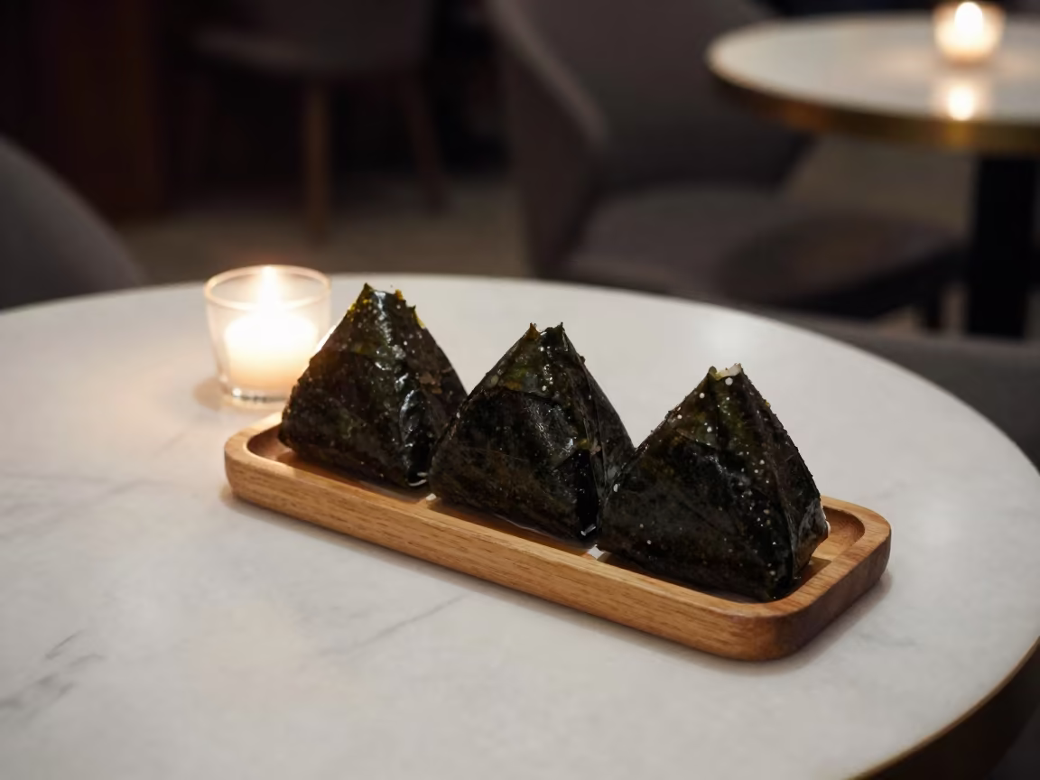 Nori Wrapped Onigiri on Marble Table at Night in on a marble cafe table in Nanning
