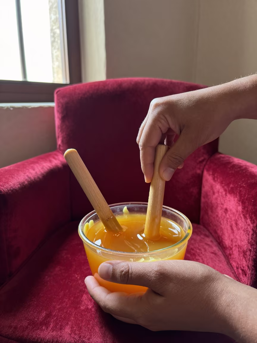 Oaxacan Candle Maker Dipping Wicks in on a velvet chair in Oaxaca