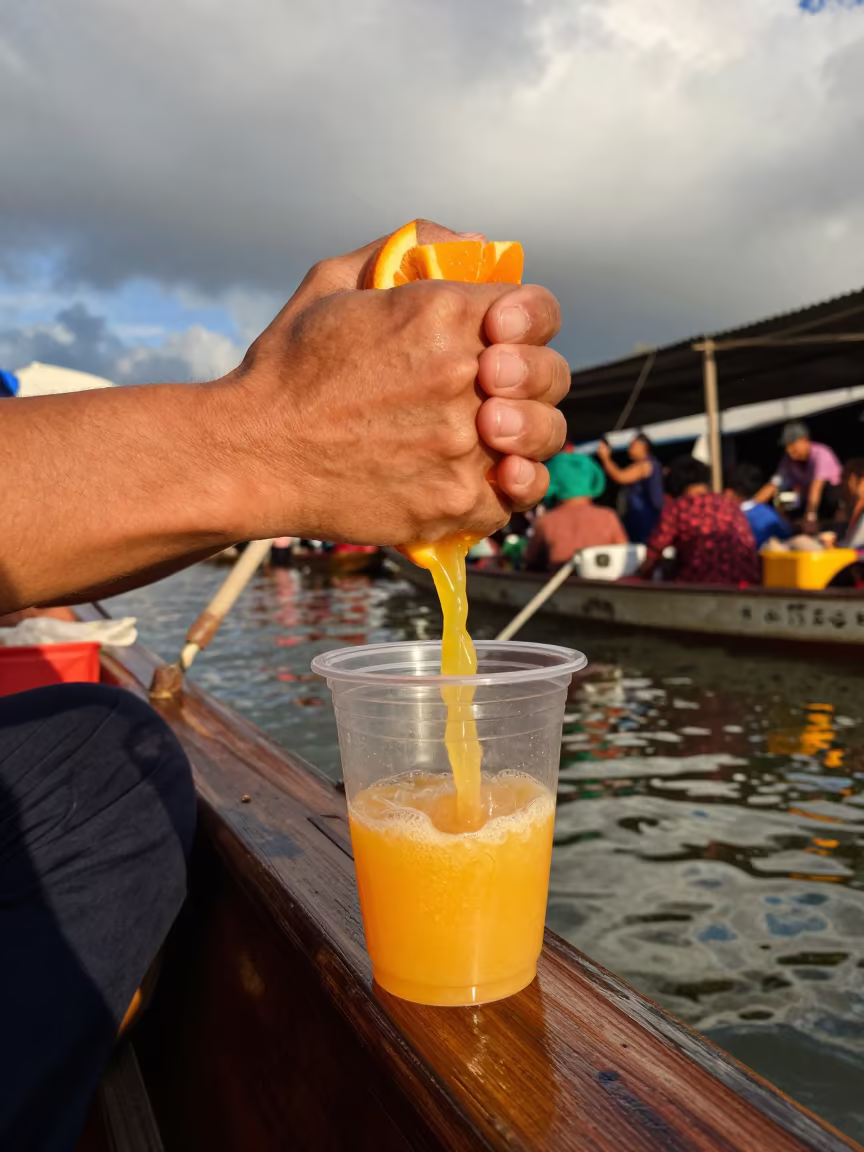 Orange Juice Vendor Squeezing Fruit on Boat in at a floating market boat in Fuzhou