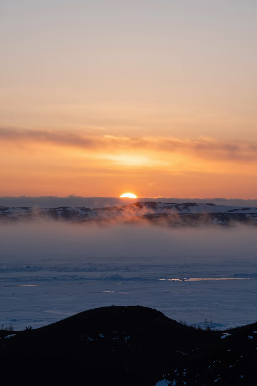 Orange Polar Sunset Over Misty Anchorage Ice in from a ridge above layered foothills near Anchorage