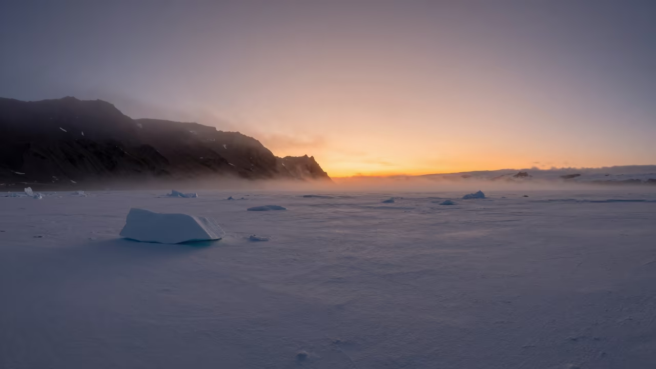 Orange Polar Sunset Over Icelandic Pack Ice in from a ridge above layered foothills in Iceland