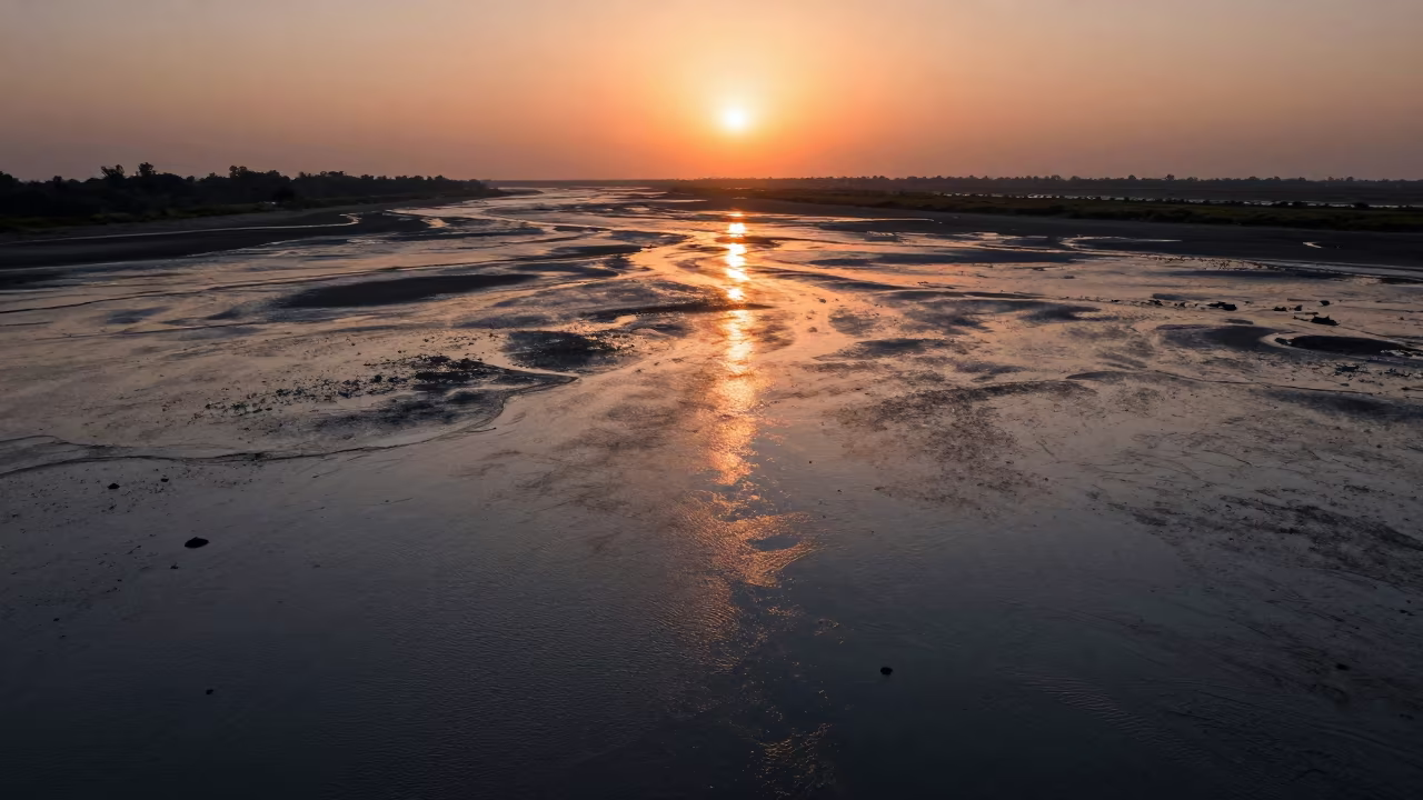 Orange Sunset Reflection on Wet Tidal Flats in across a wide valley floor near Hyderabad