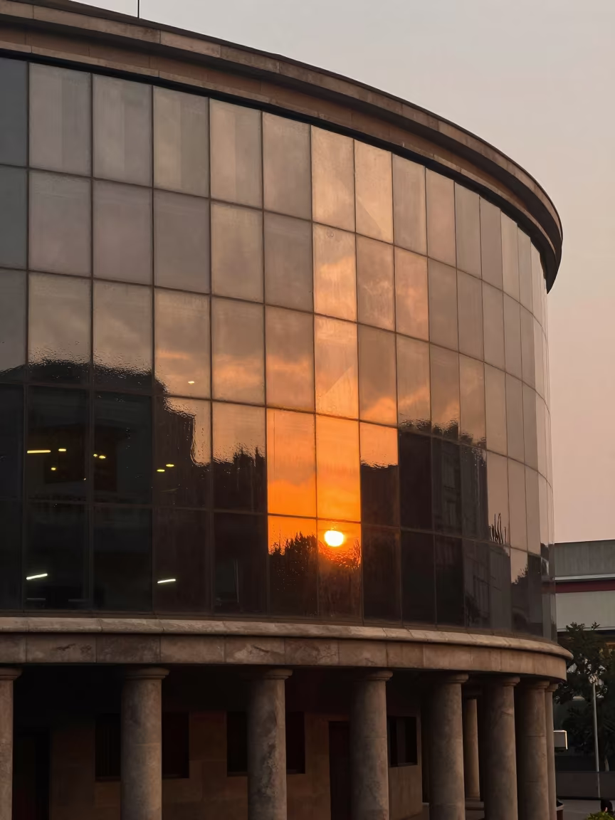 Orange Sunset Reflections on Curved Glass Ondo in along a colonnaded facade in Ondo