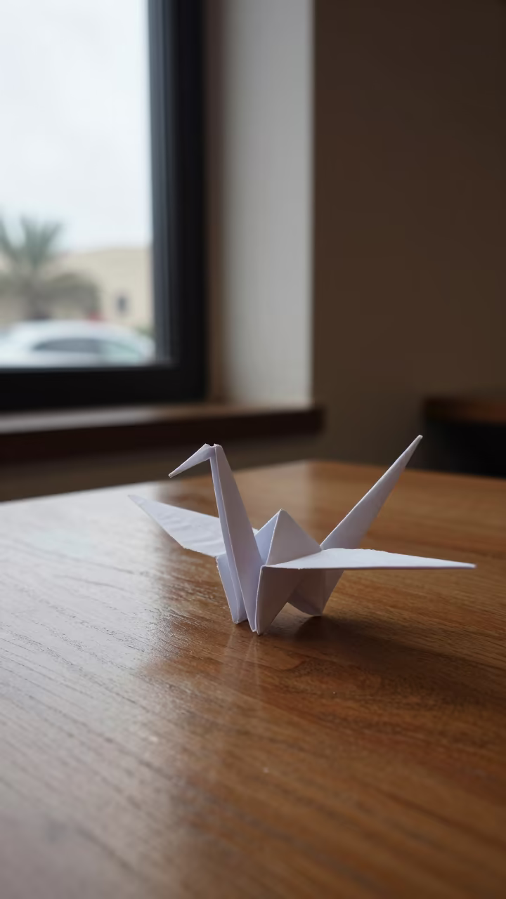 Origami Crane Shadow on Cafe Table in on a cafe table by a window in Salalah