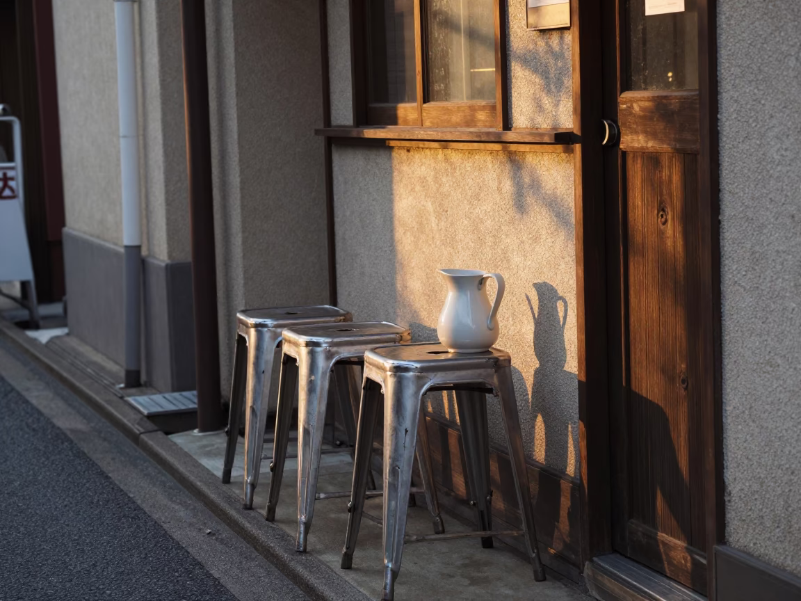 Osaka Japan street scene with metal stools and ceramic pitcher in honeyed evening light in in Osaka, Japan