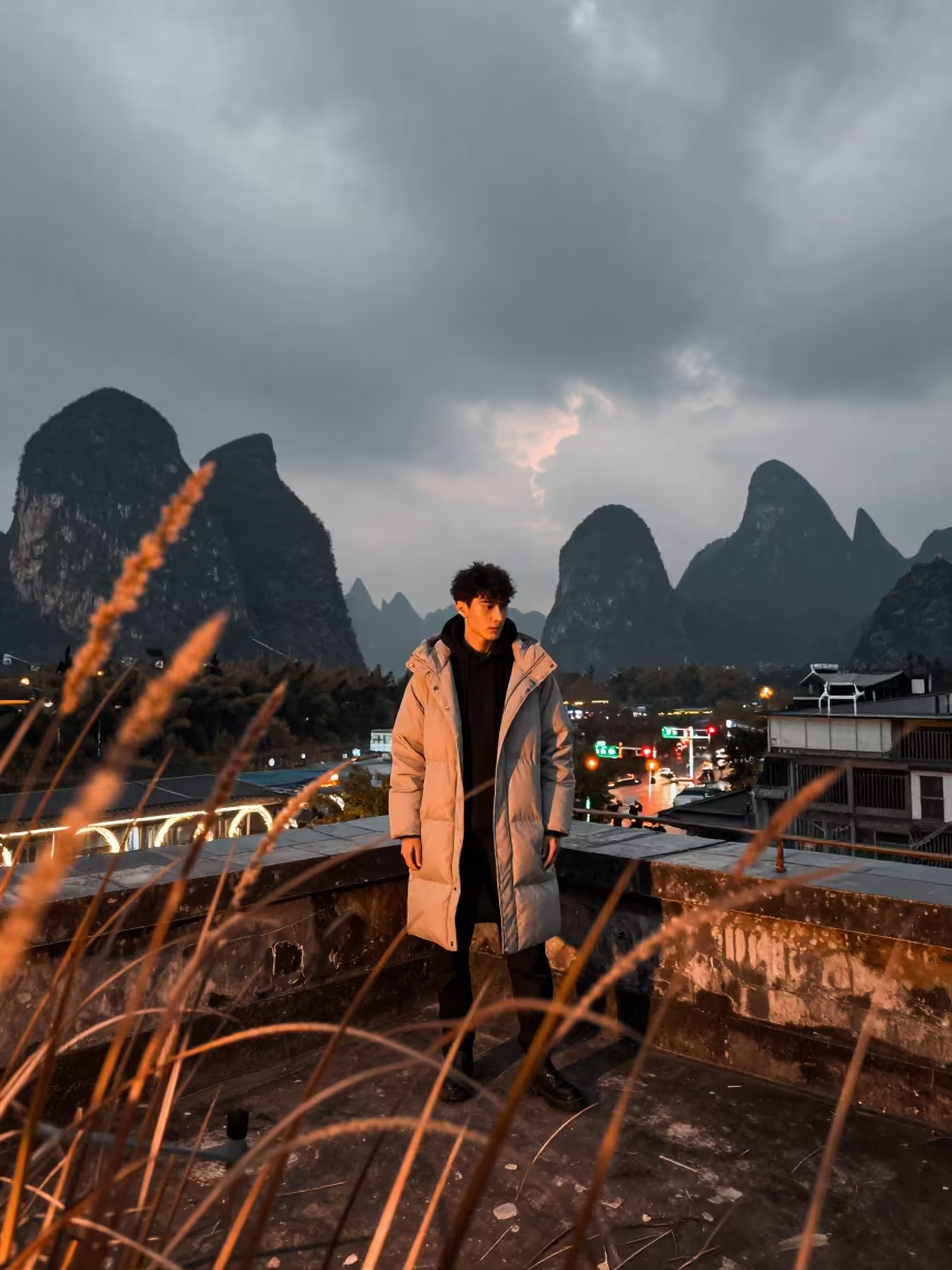 Outerwear Editorial in Dune Grass Before Dusk in on a rooftop above evening traffic in Guilin