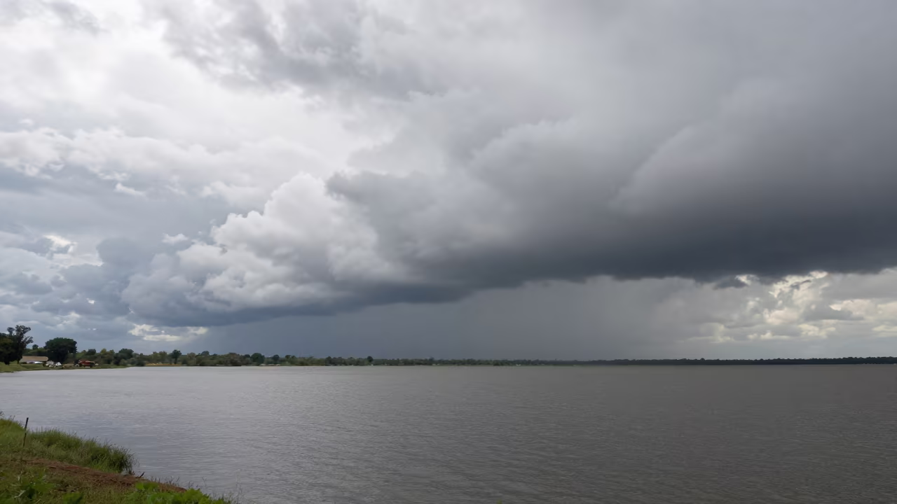 Overcast Sky Pressing Grey November Lake in over a horizon of stacked thunderheads near Garoua