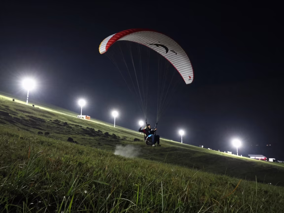 Paraglider Soaring Above Green Valley Near Almaty in in a village lane near Almaty