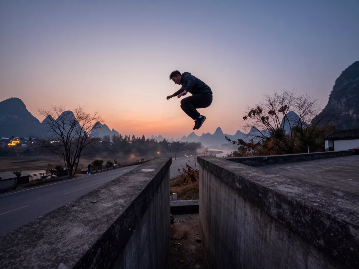 Parkour athlete jumping rooftop ledges at blue hour Yangshuo in at a roadside stop near Yangshuo