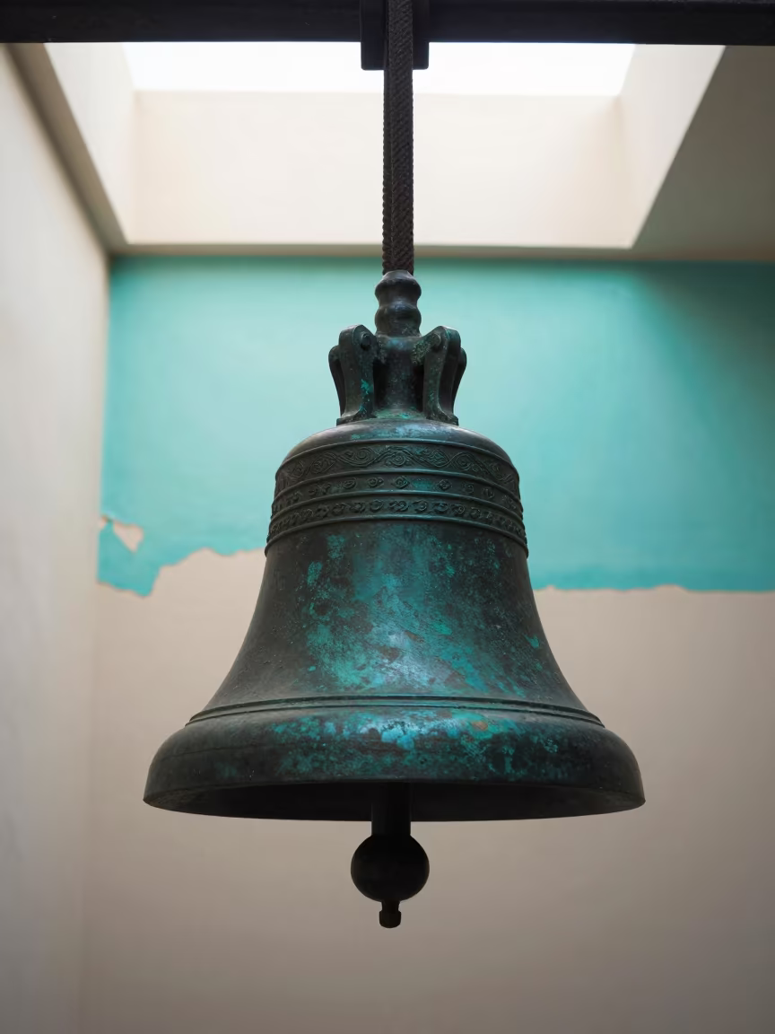 Patina on Weathered Bronze Bell in Rize in against weathered turquoise paint in Rize