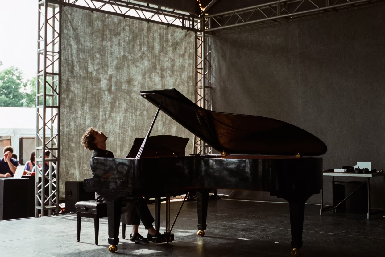 Pianist Arching Back Silhouetted Against Noon Light in on a dimly lit stage in Brussels