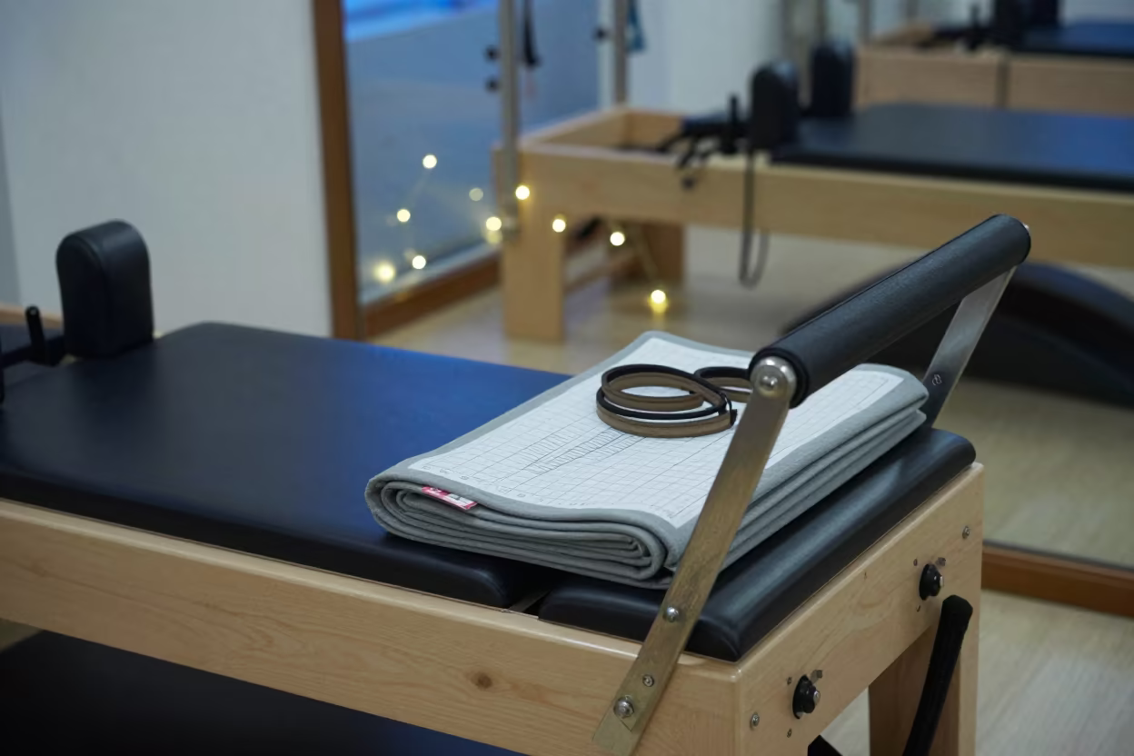 Pilates reformer corner with mats and springs in inside a barre room under soft morning light in Xining