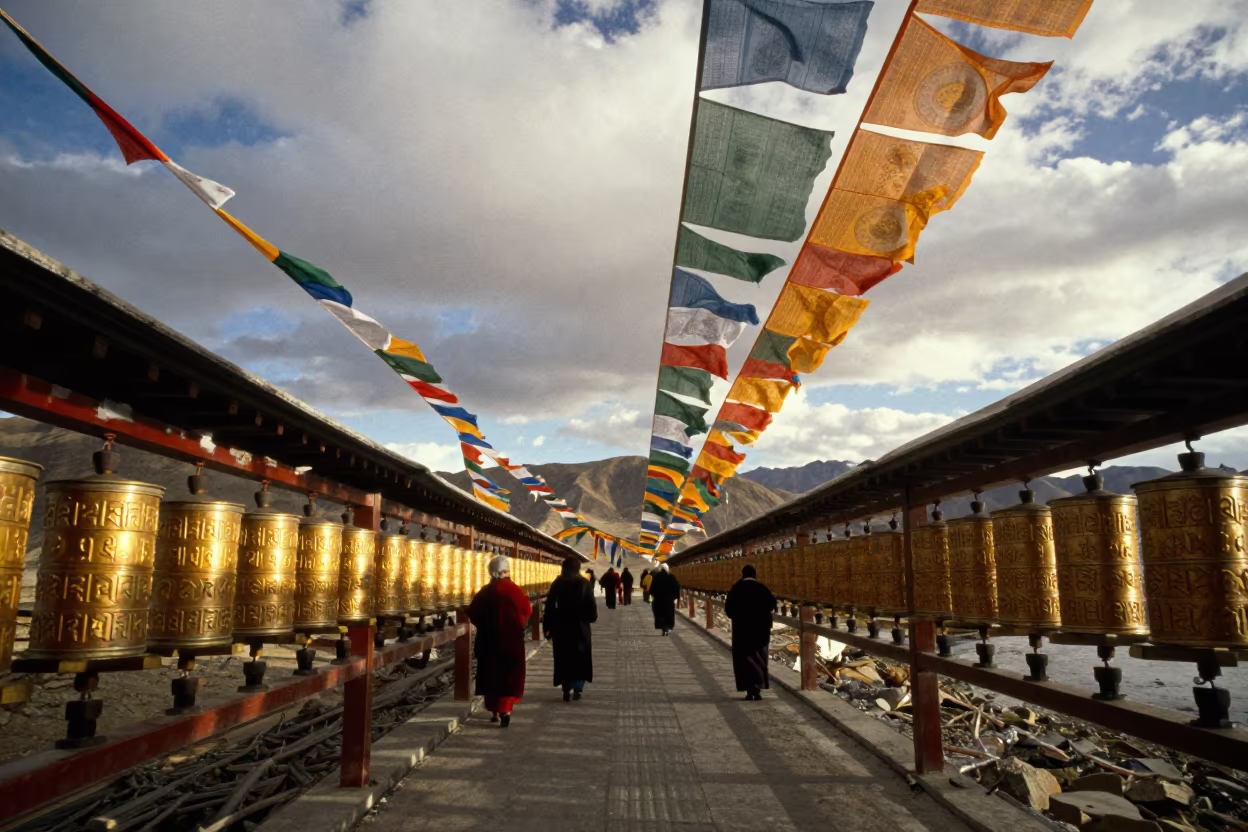 Pilgrims Spin Brass Prayer Wheels at Golden Hour in along a high mountain pass beneath prayer flags near Leh