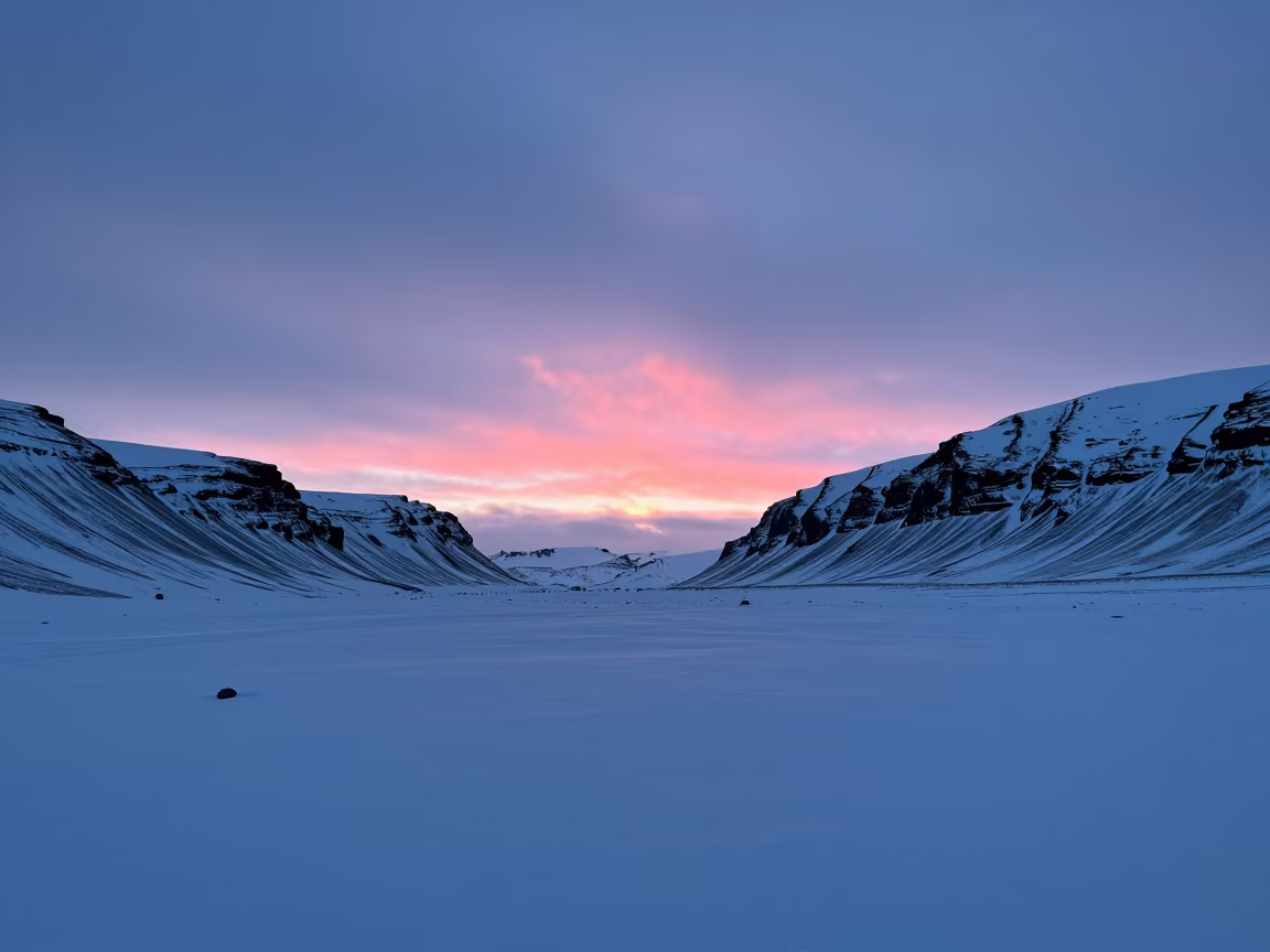 Pink Dawn Light Over Iceland Snow Valley in across a wide valley floor in Iceland