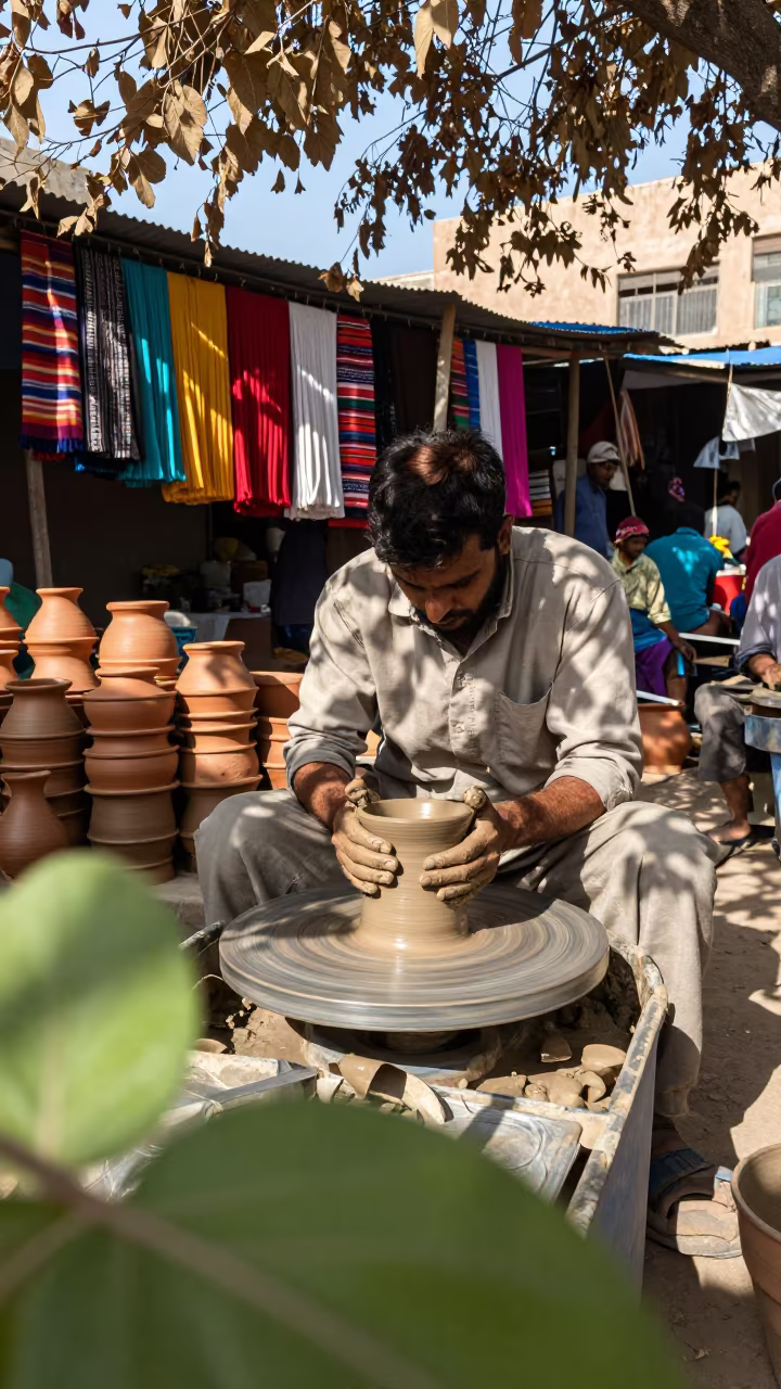 Potter Shaping Clay at Market Stall in at a textile trader's stall in Shah Faisal Town