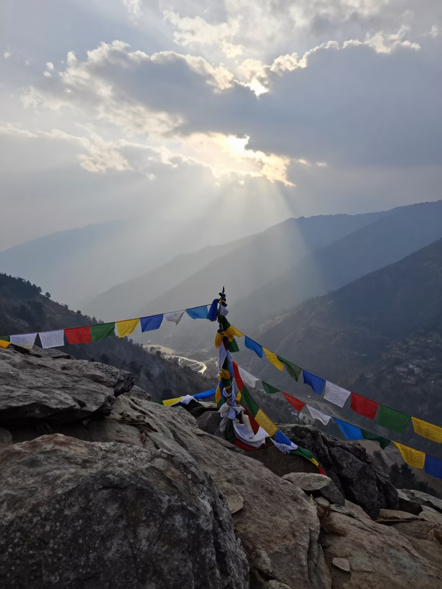 Prayer Flags Over Shimla Valley in Morning Haze in at a rocky saddle overlooking a mountain valley near Shimla