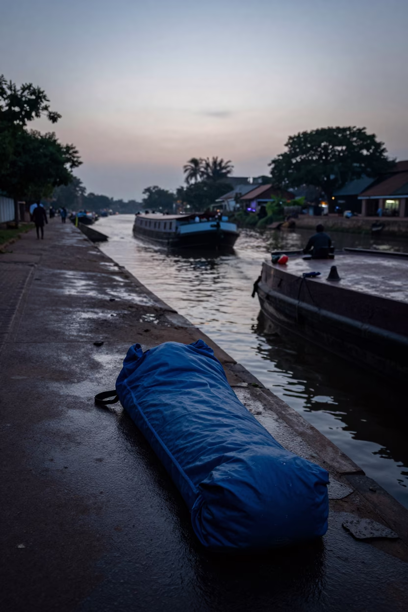 Pre-dawn Accra street scene with sleeping bag and barge on canal in in Accra, Ghana