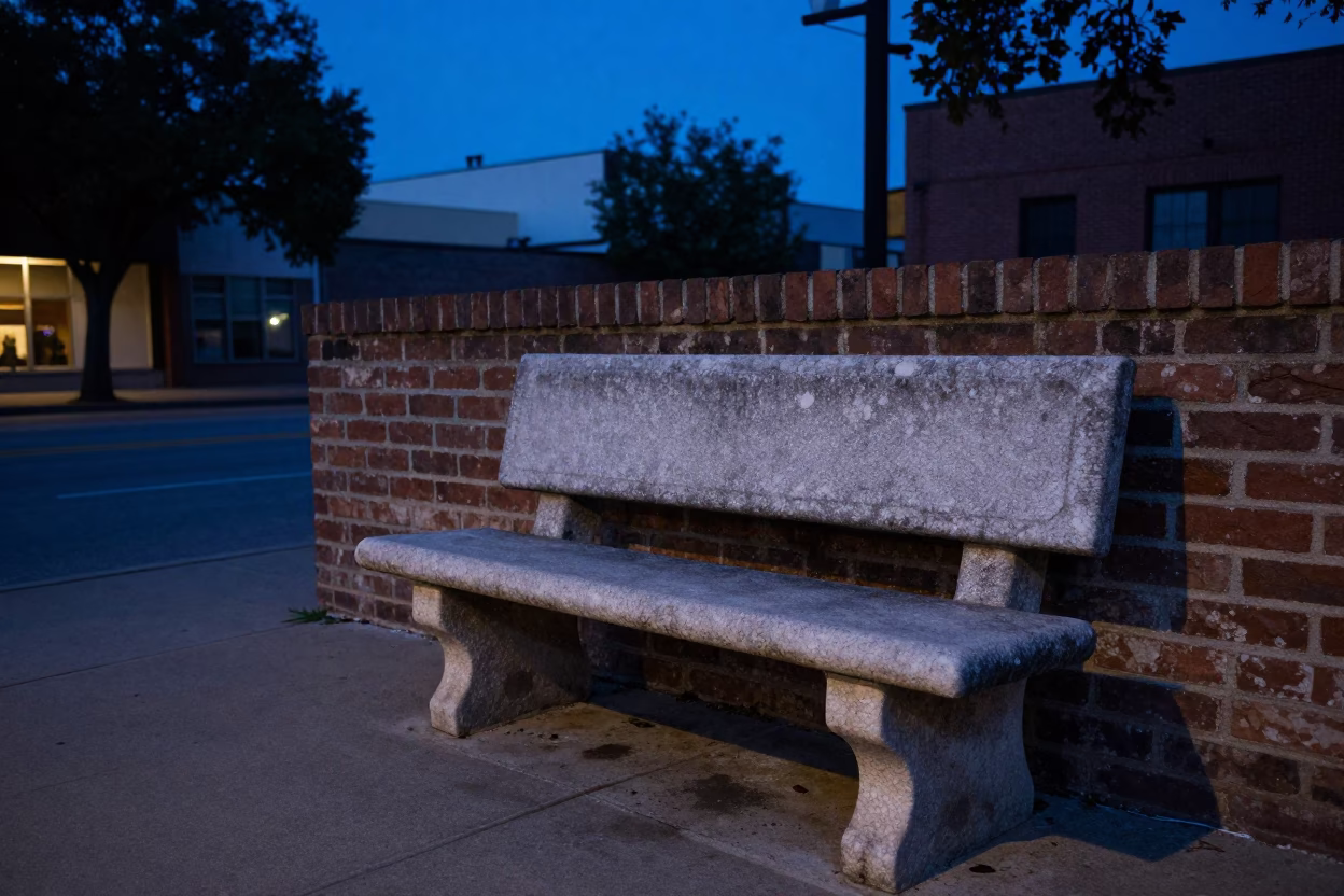 Pre-dawn Austin Texas street scene with stone bench and grease sheen on frame in in Austin, Texas, United States