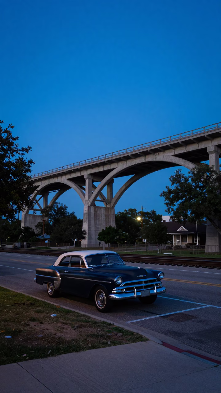 Pre-dawn Austin Texas street scene with vintage car and railway viaduct in in Austin, Texas, United States