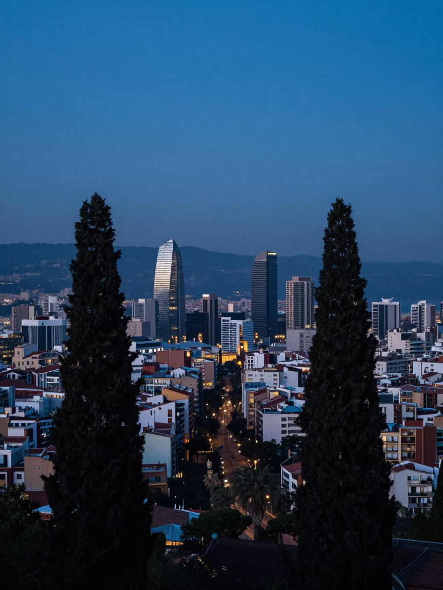 Pre-dawn Barcelona Skyline View from Tibidabo Hill with Cedar Trees and City Lights in in Barcelona, Spain