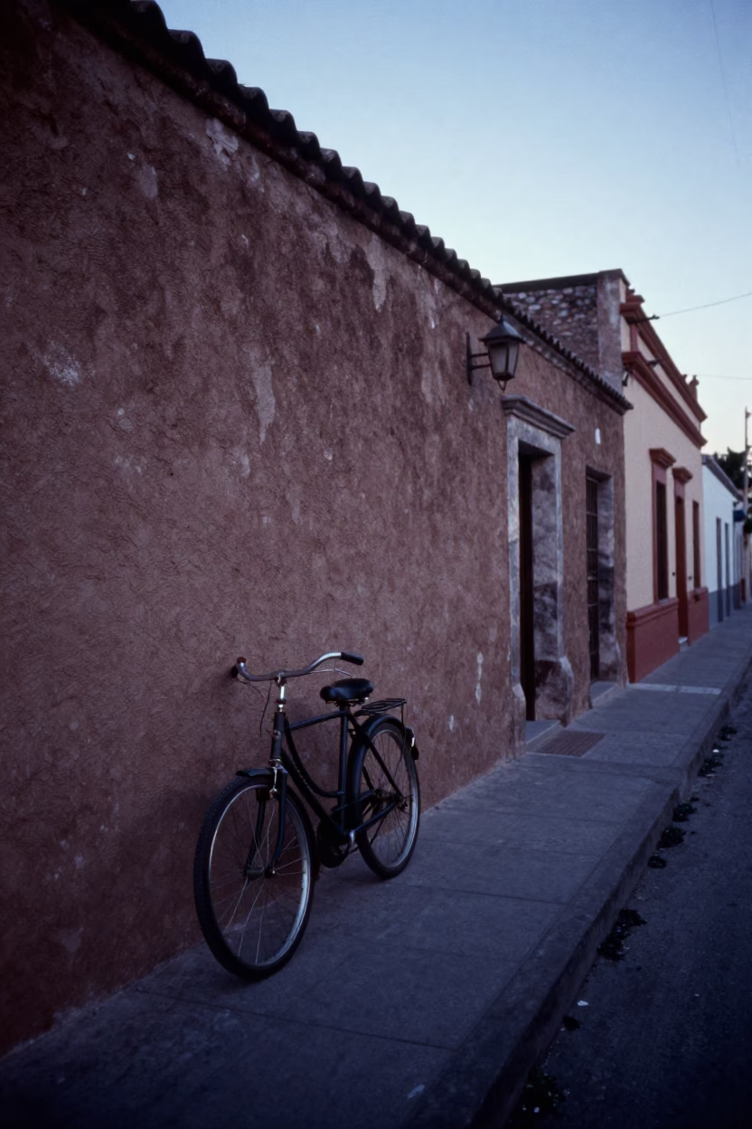 Pre-dawn Guadalajara street scene with vintage bicycle and textured adobe wall before sunrise in in Guadalajara, Mexico