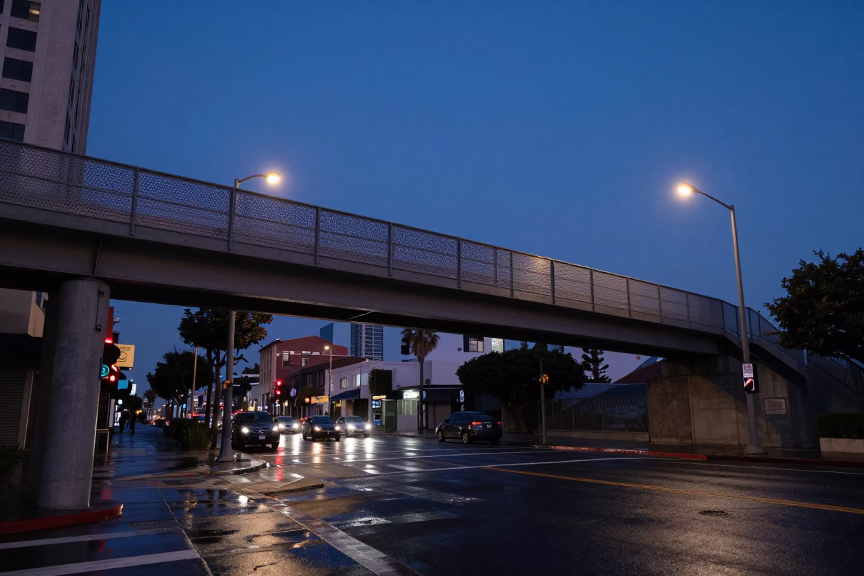 Pre-dawn Los Angeles street scene with pedestrian overpass and wet pavement reflections in in Los Angeles, California, United States