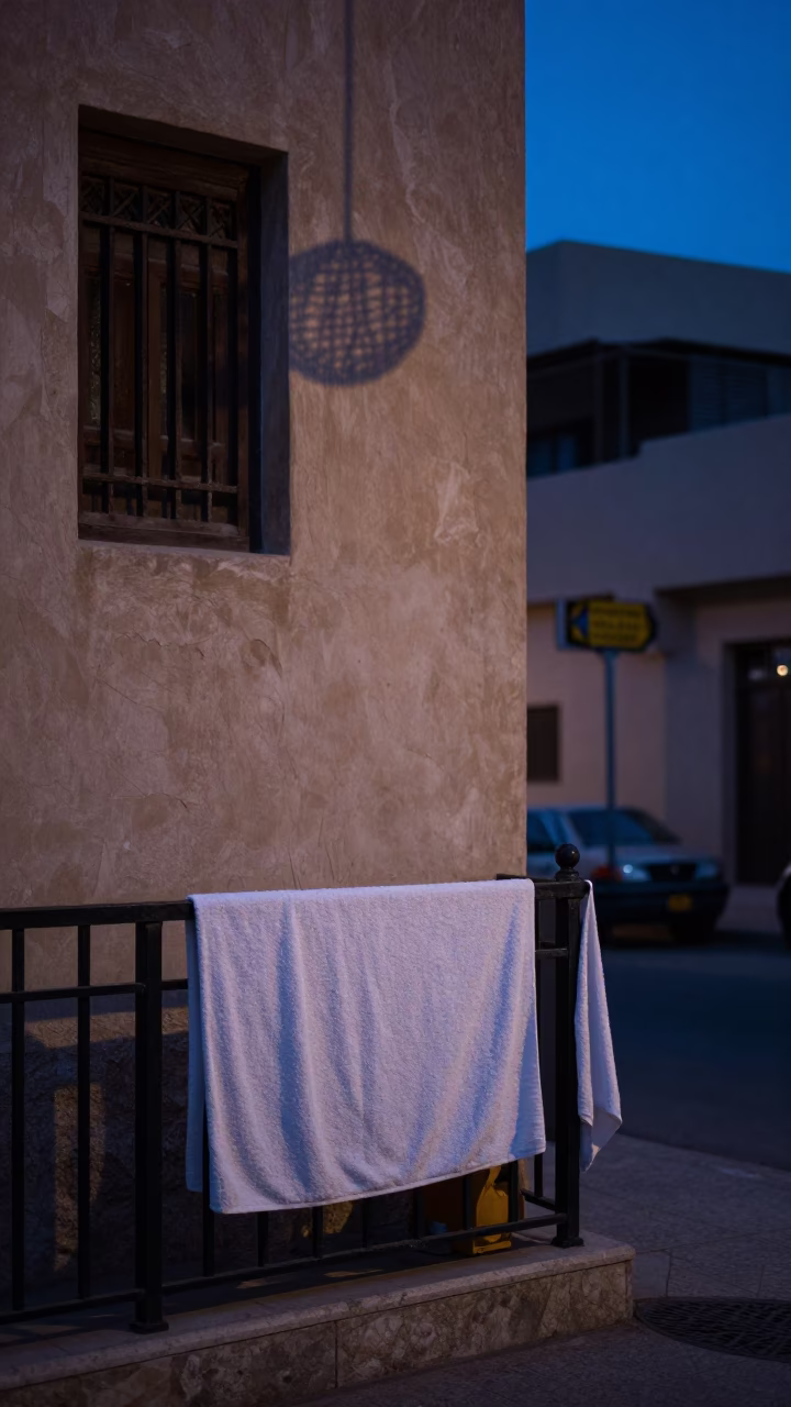 Pre-dawn Muscat street scene with towel on rail and wicker shadow in in Muscat, Oman