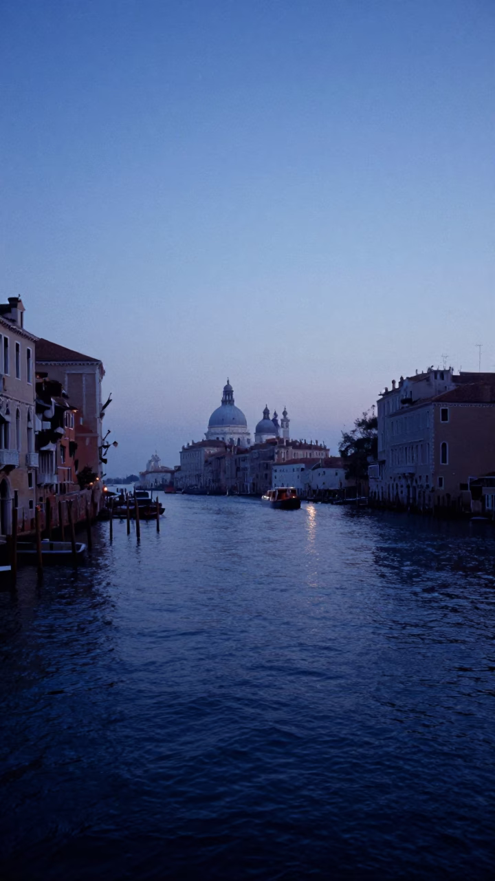 Pre-dawn Venetian canal scene with cargo ship horizon and colored glass bottle in in Venice, Italy