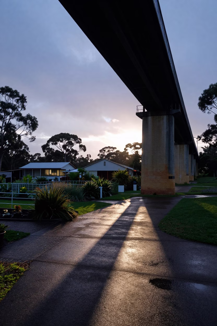 Pre-dawn viaduct shadow across Adelaide allotment gardens after rain in in Adelaide, South Australia, Australia
