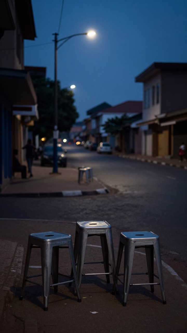 Predawn Accra Street Scene with Metal Stools and Faint Ambient Light in Ghana in in Accra, Ghana