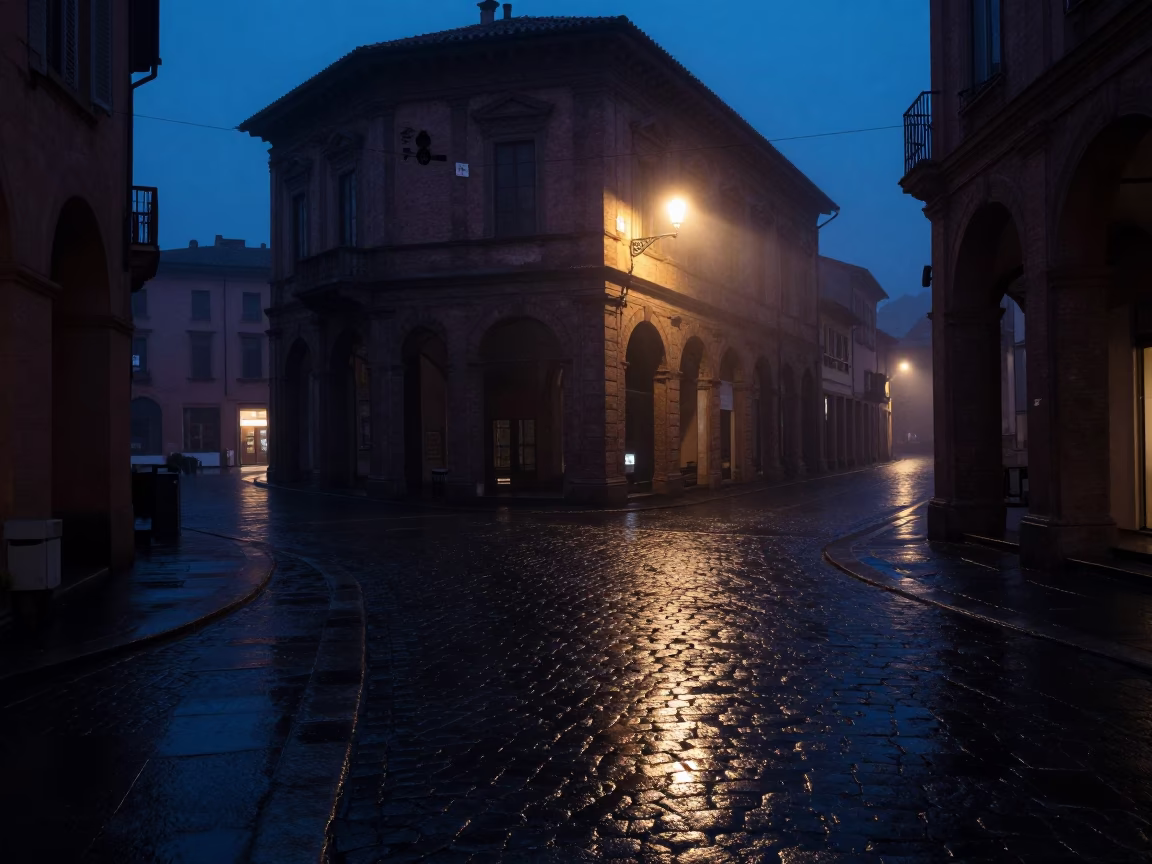 Predawn Bologna Italy street scene with wet cobblestones and distant church spire in in Bologna, Italy