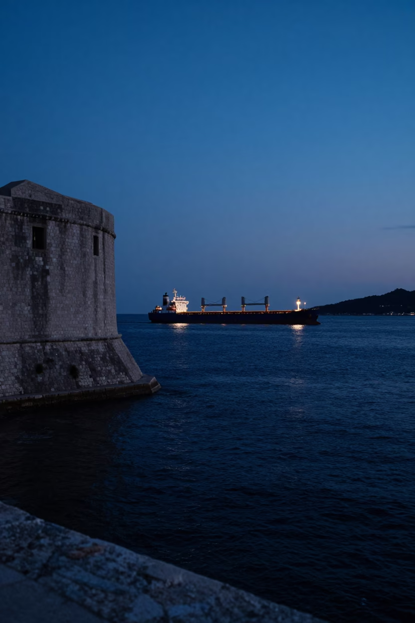 Predawn Dubrovnik Harbor with Cargo Ship and Beacon Light in Mist in in Dubrovnik, Croatia