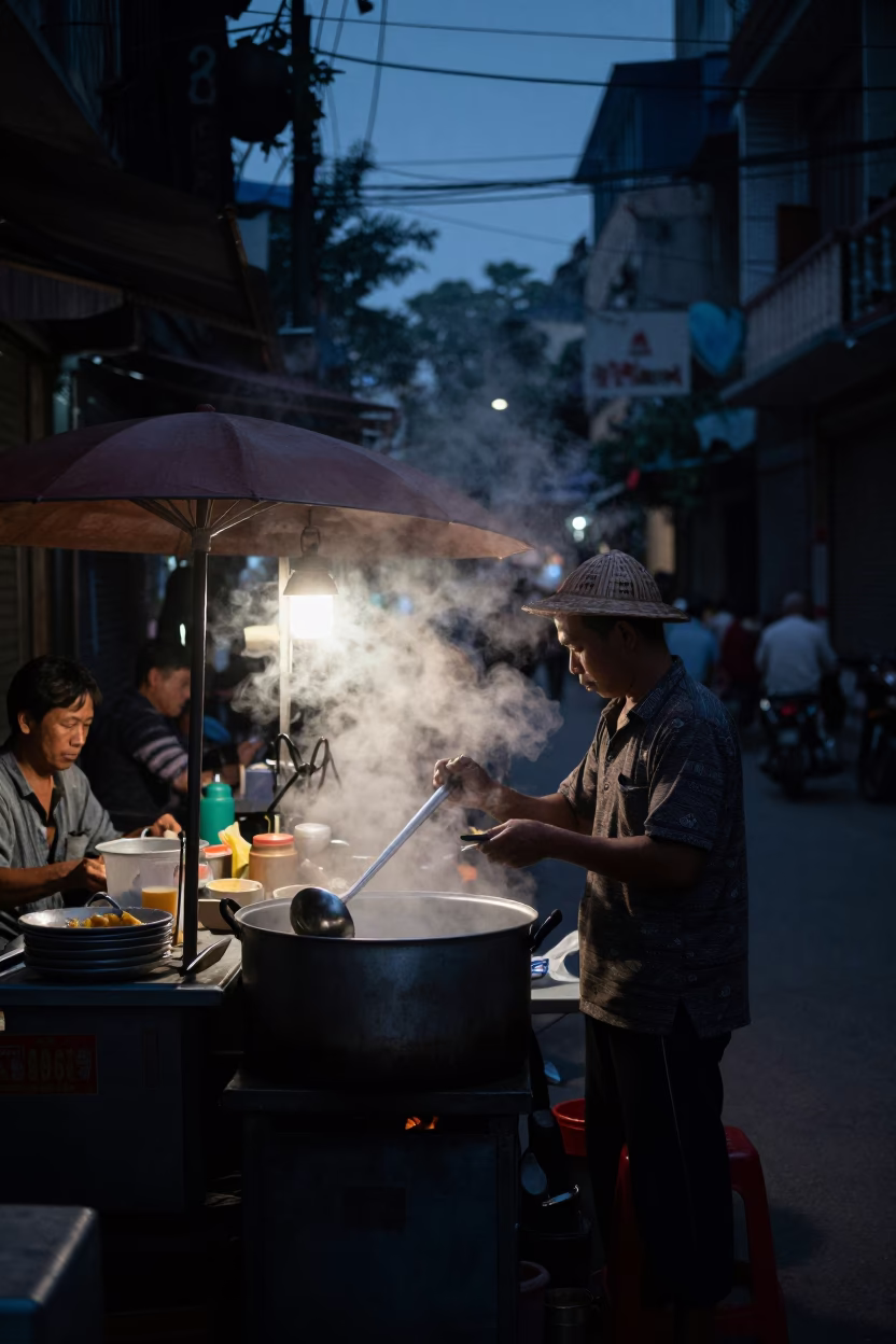 Predawn street scene in Hanoi Vietnam with steam from street food vendor in in Hanoi, Vietnam