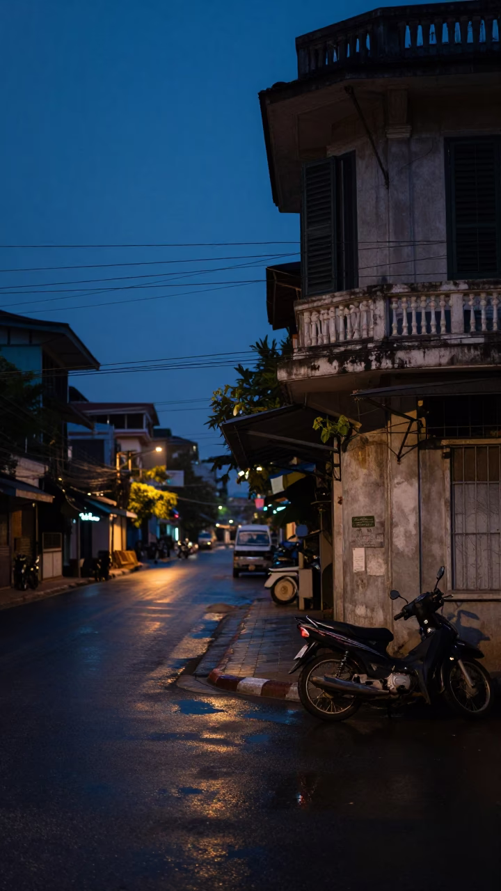 Predawn street scene in Phnom Penh Cambodia with wet pavement and distant bridge lights in in Phnom Penh, Cambodia