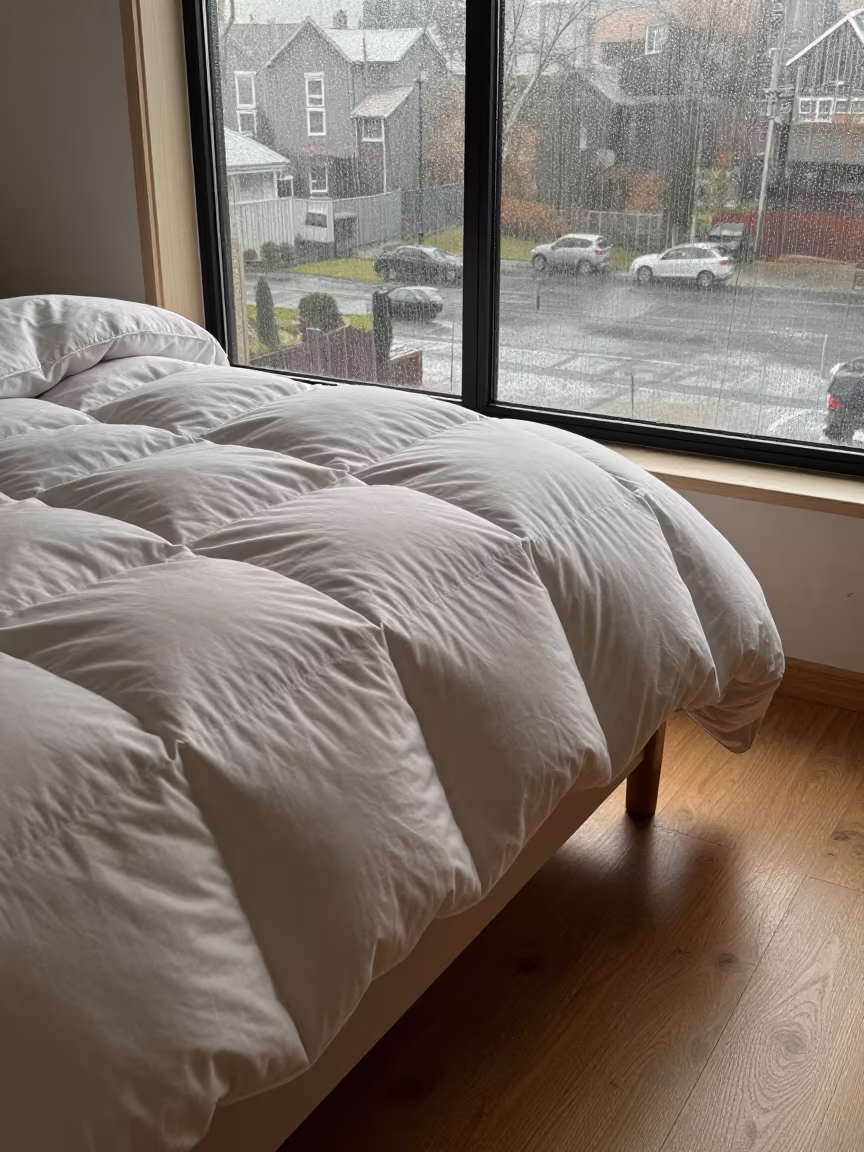 Puffed Goose Down Duvet in Sapporo Loft Dawn in beside a rain-streaked window in Sapporo