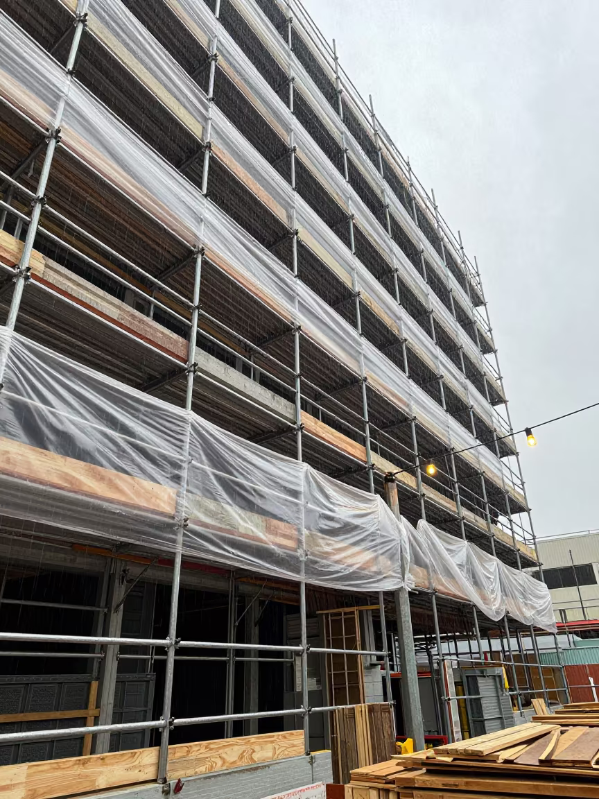 Rain on Scaffolded Los Angeles Facade with Dust and Wood in along a scaffolded facade in Los Angeles