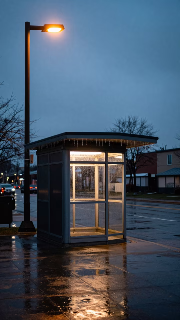 Rain-soaked kiosk under sodium light at twilight in outside a metro entrance in Mississauga