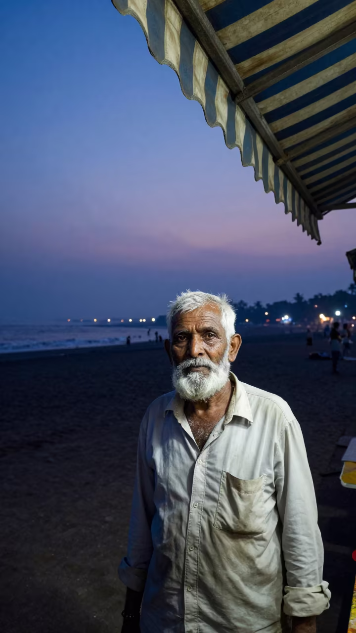 Retired Lighthouse Keeper Under Mumbai Awning in under a striped market awning near Bandra, Mumbai