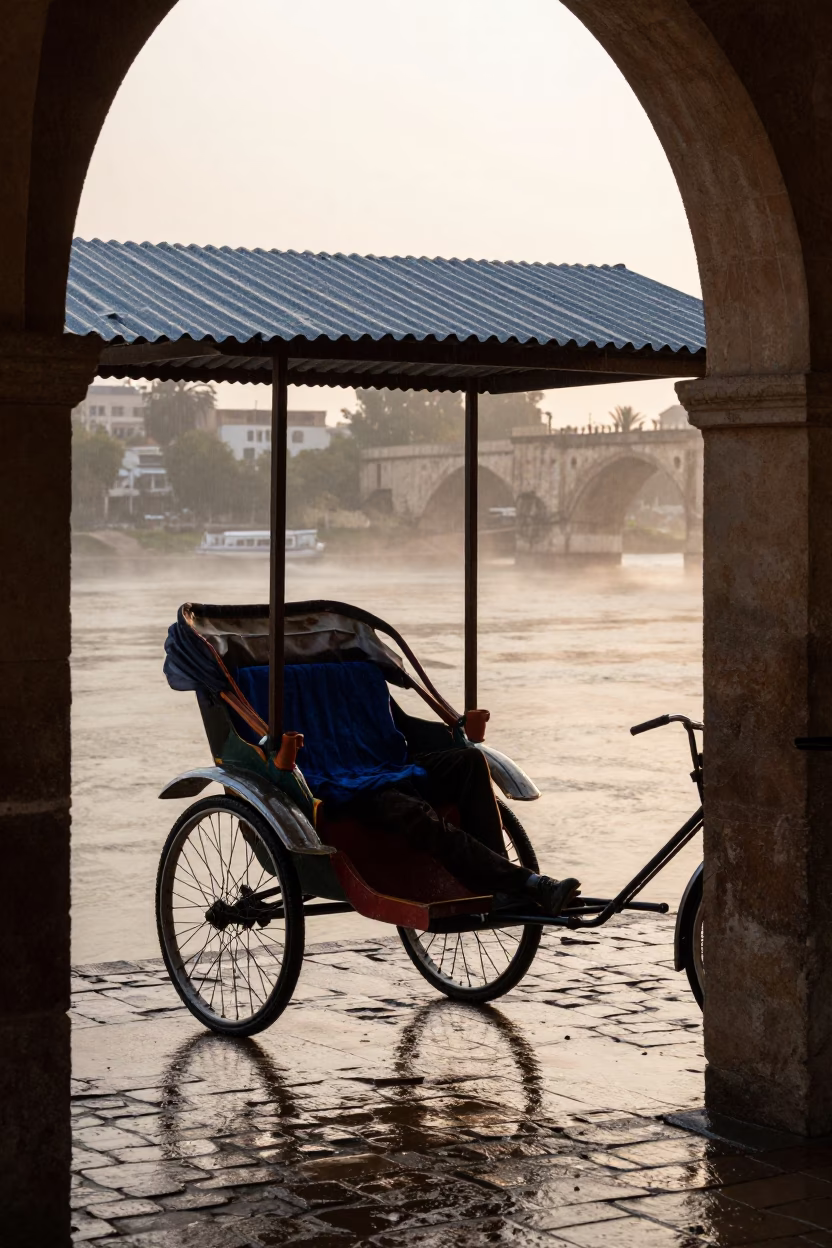 Rickshaw Puller Resting in Rain at Tlemcen Riverside in near a riverside landing in Tlemcen